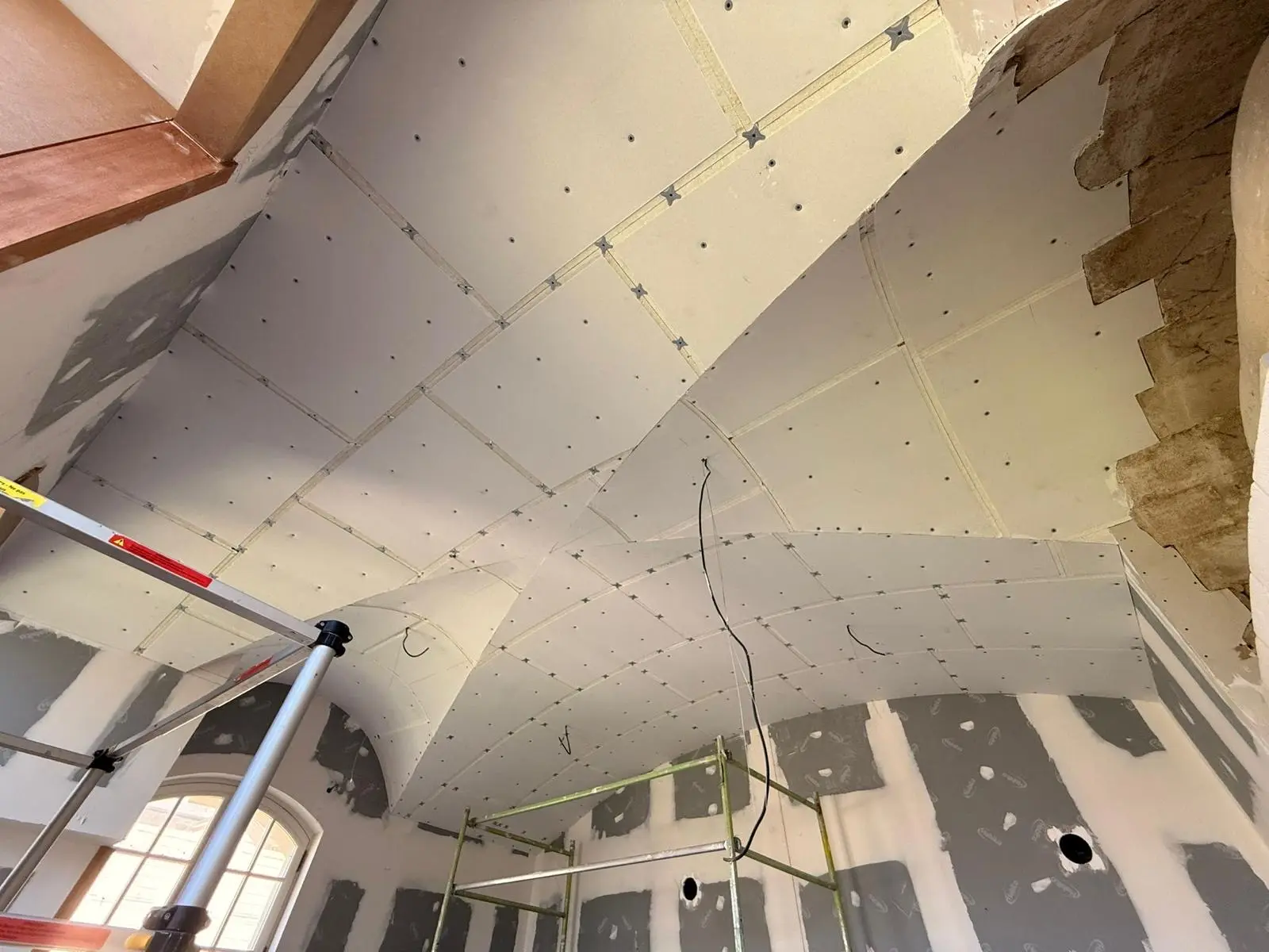 Plafond en phase de plaques avec bandes de joint et perche laser de réglage