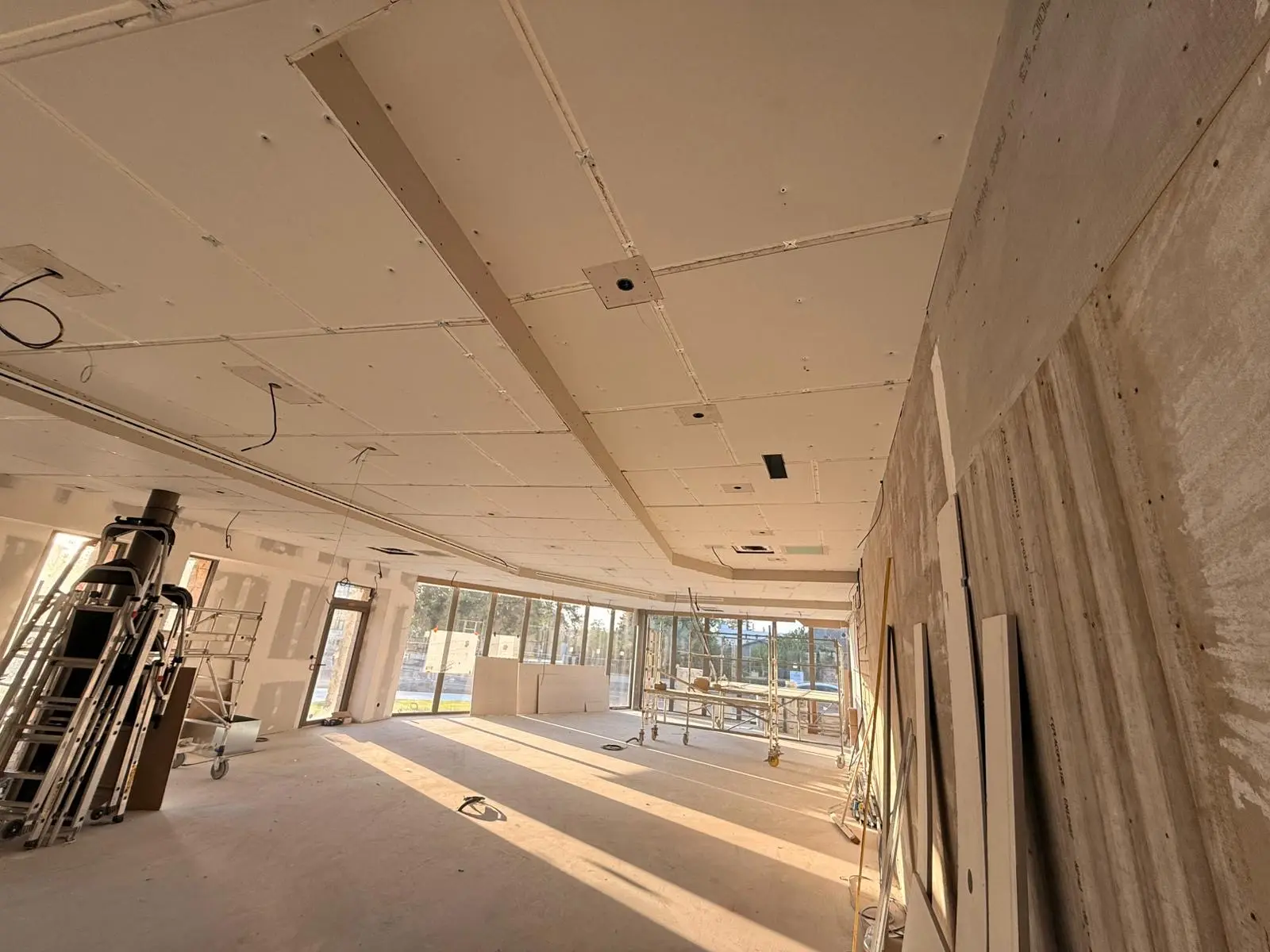 Grand plateau en chantier sous plafond plaqué, ouvertures en façade