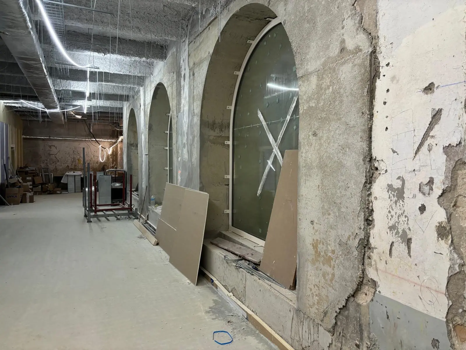 Cave voûtée en pierre brute avant travaux, arcades et réseaux apparents