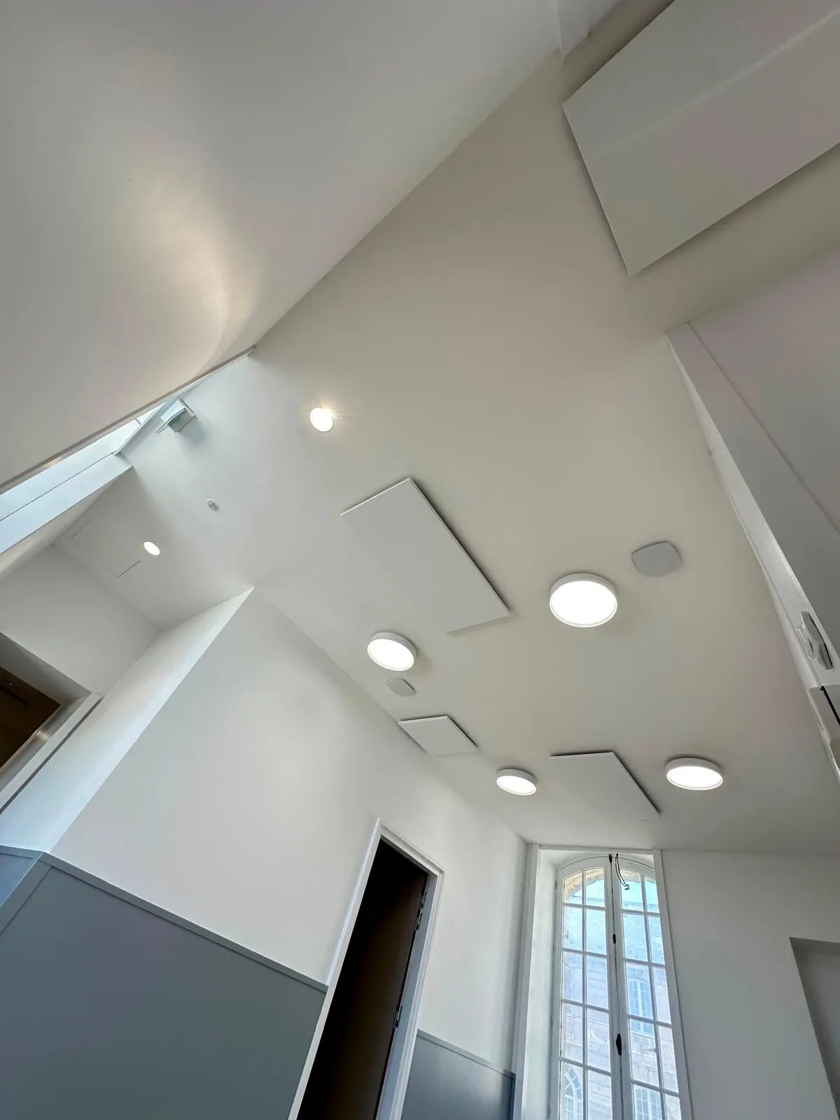 Pièce sous plafond blanc lisse avec spots encastrés et trappe affleurante