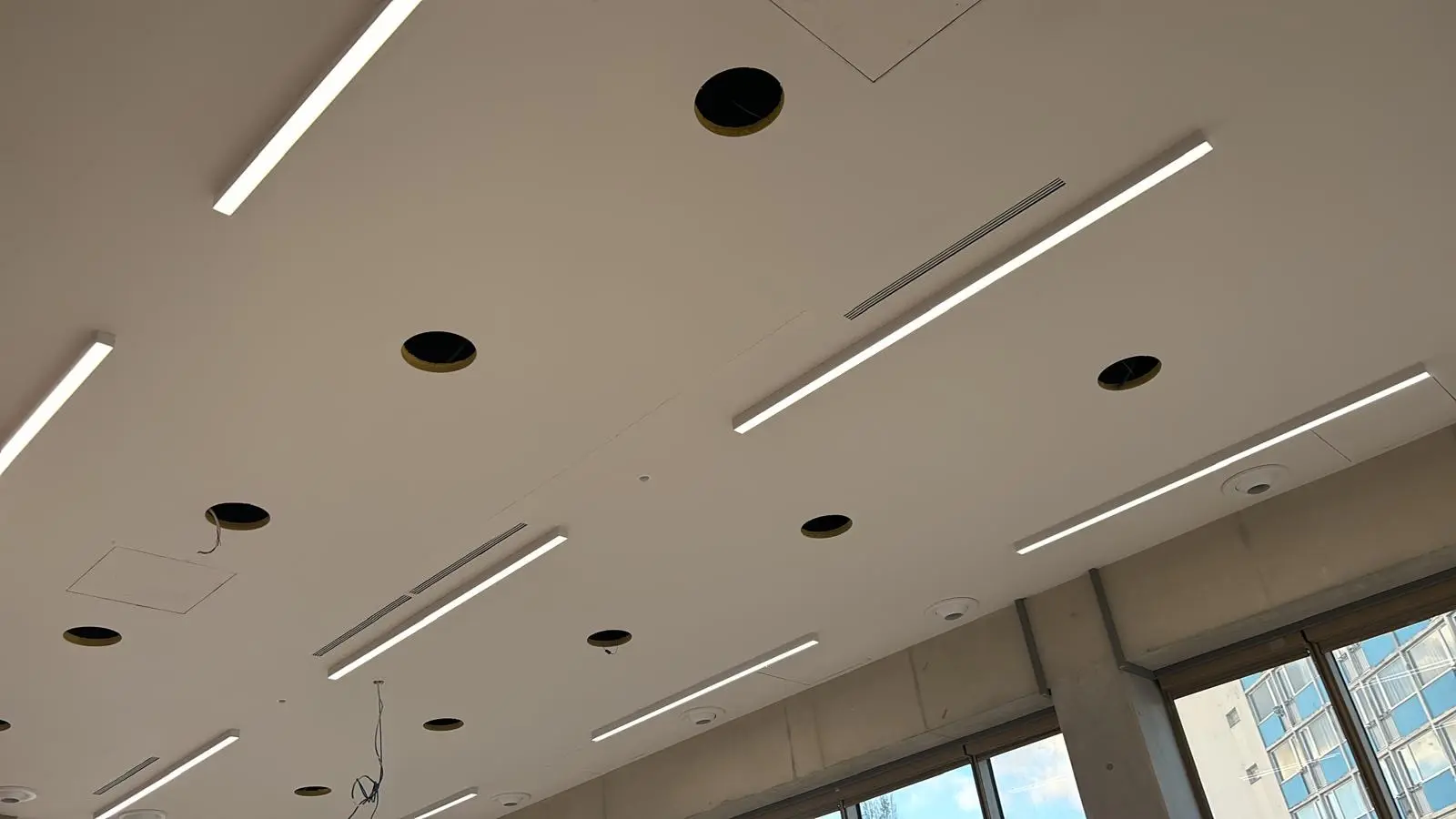 Plafond continu avec réglettes lumineuses, spots et trappes affleurantes
