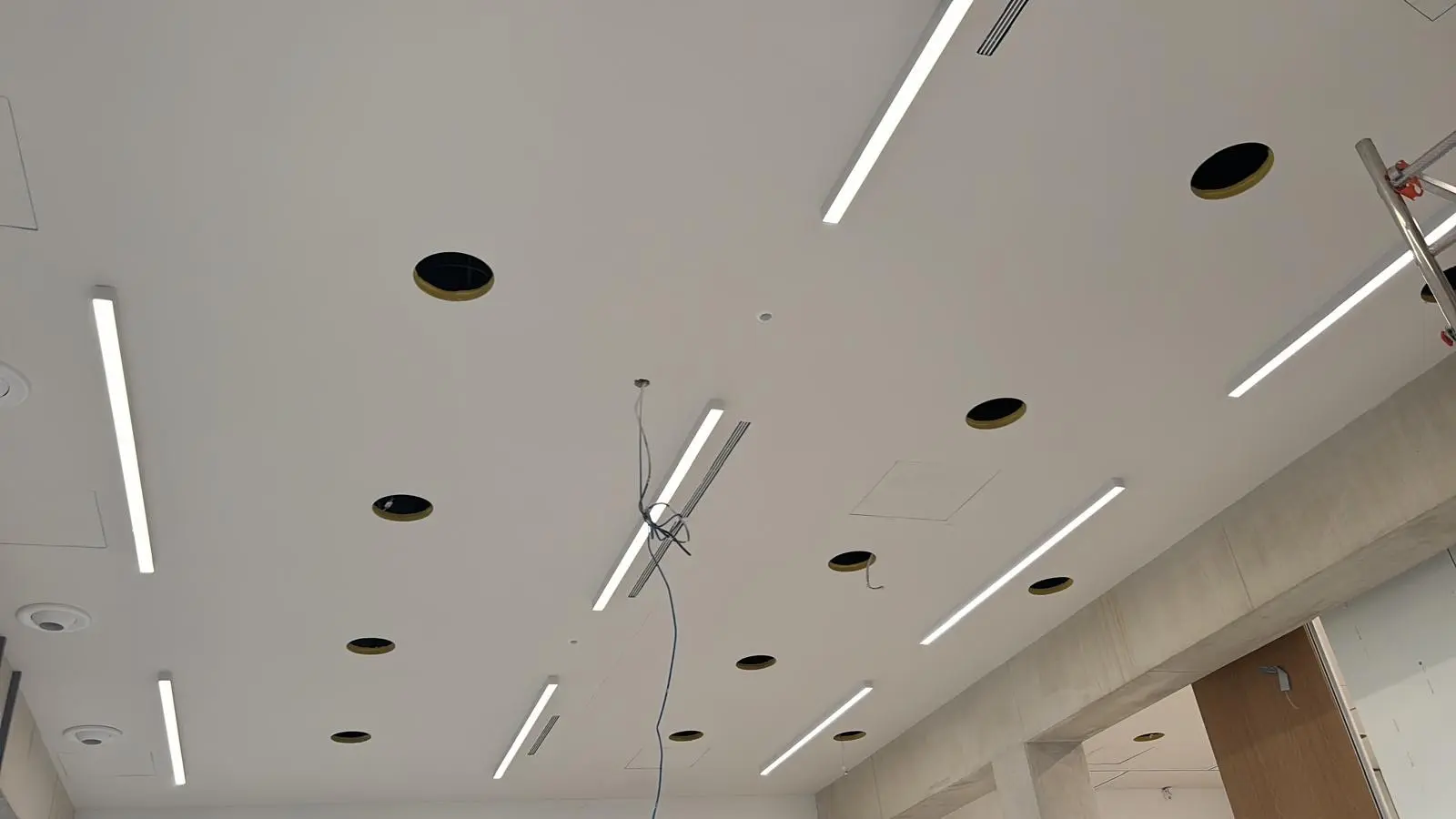 Plafond blanc en cours de finition avec réglettes et spots encastrés