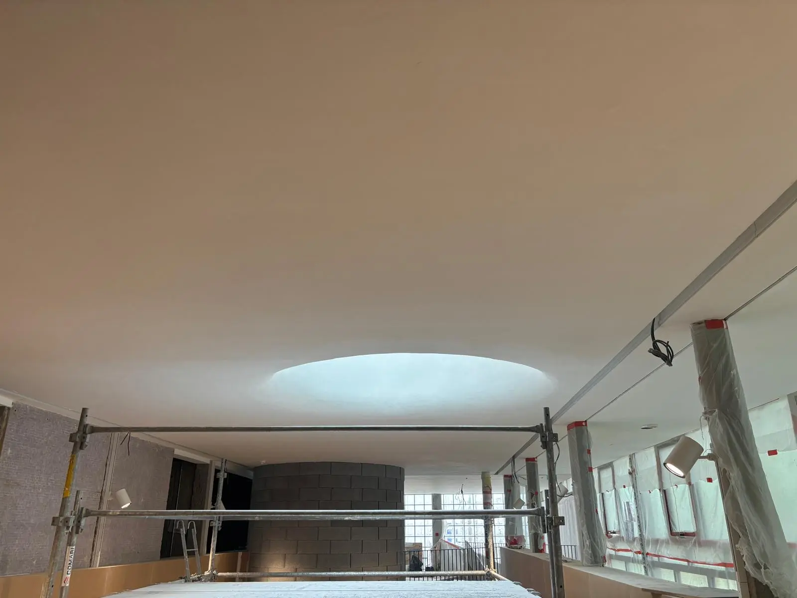 Oculus lumineux circulaire dans un plafond monolithique de hall