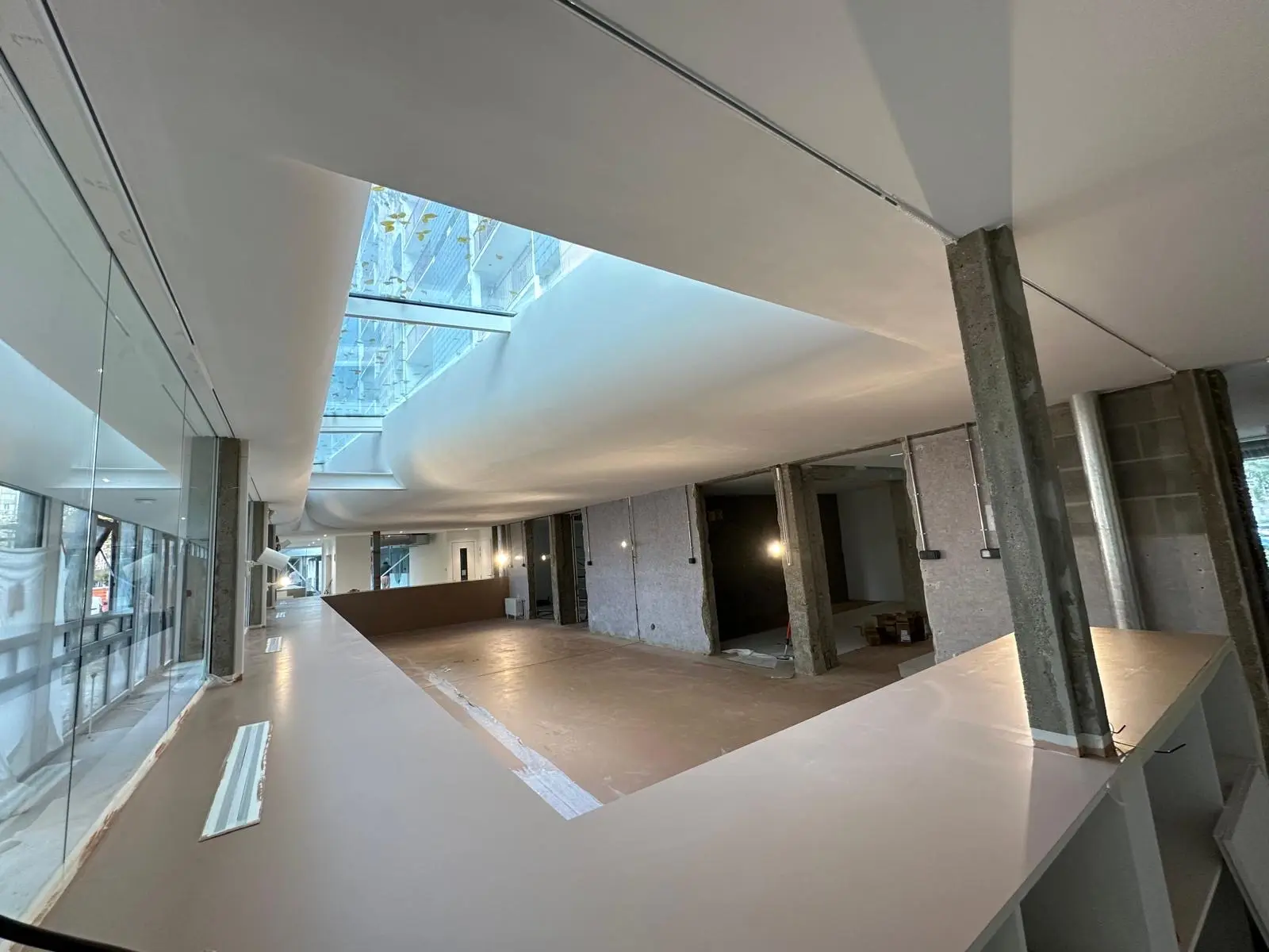 Atrium et passerelle sous plafond lisse, poteaux béton apparents