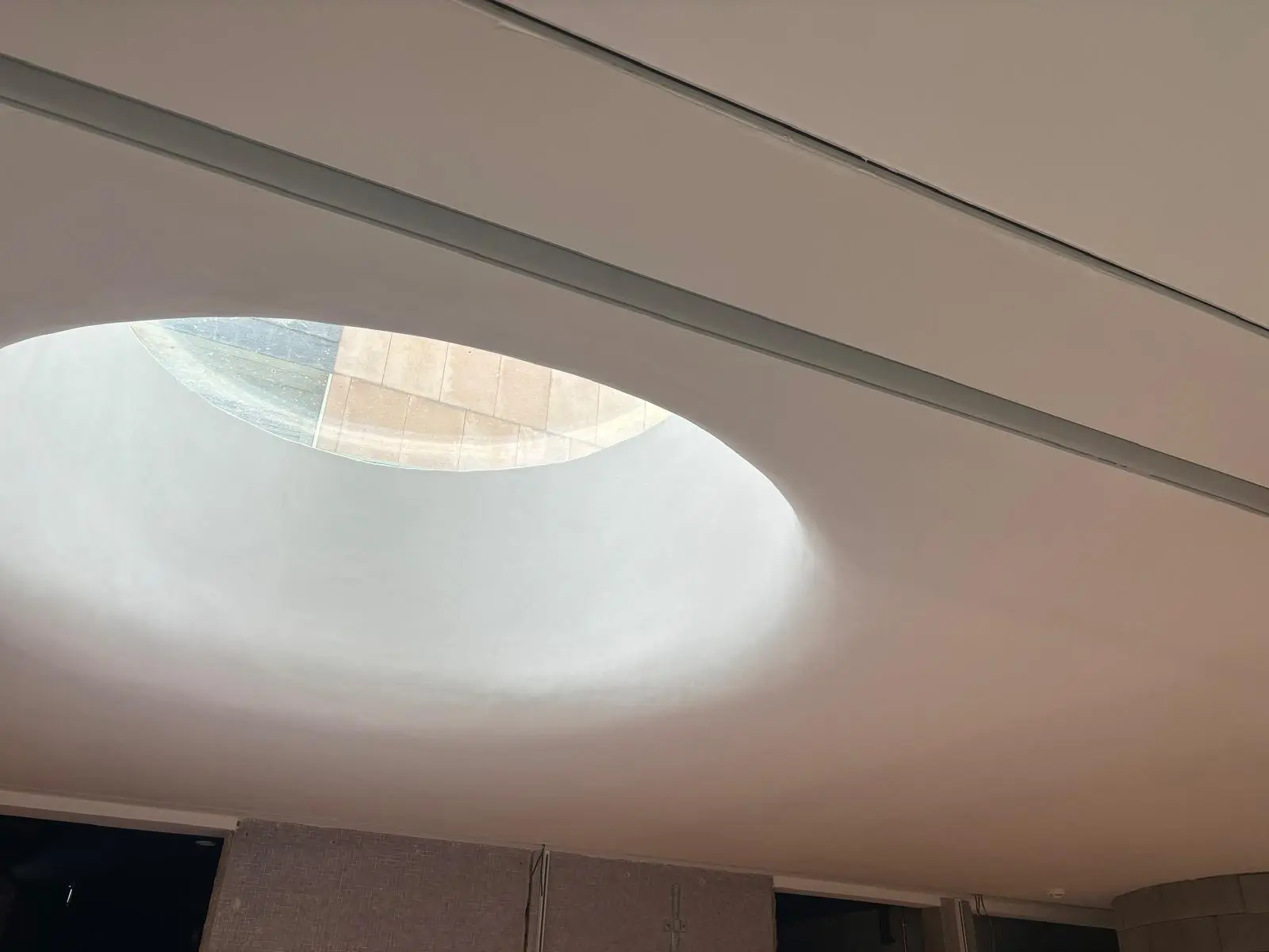 Détail d'un oculus circulaire rétroéclairé creusé dans une surface continue