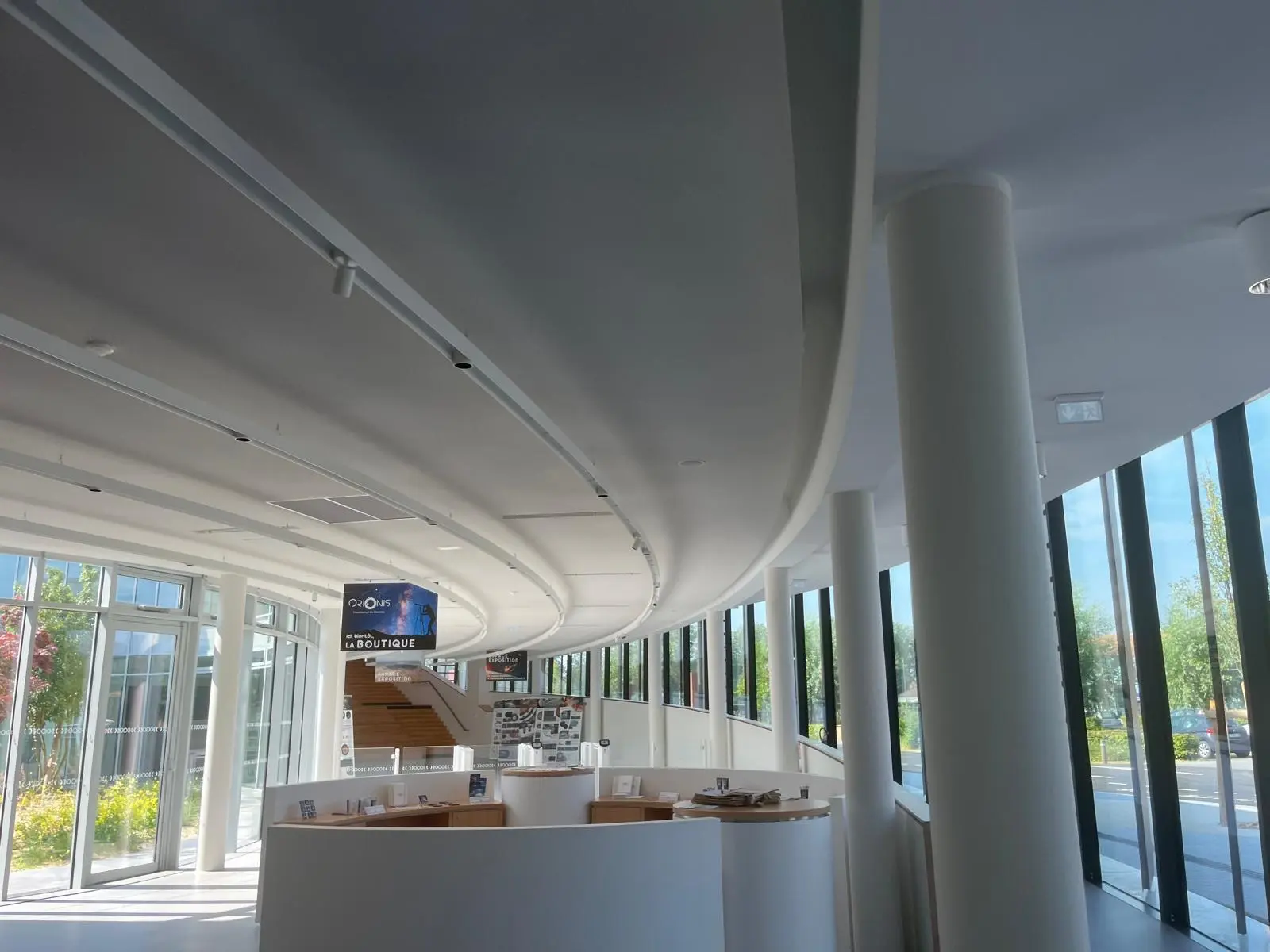 Retombées courbes du plafond de la galerie, poteaux ronds et vitrage