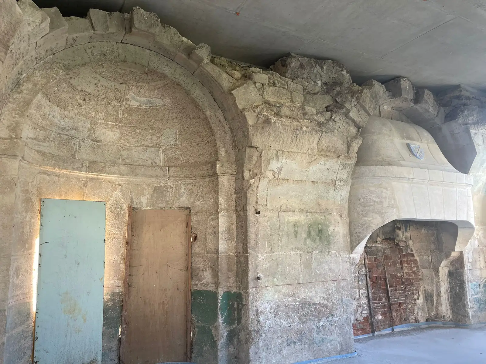 Deux cheminées de pierre alignées avant travaux, arcs de décharge appareillés et portes anciennes