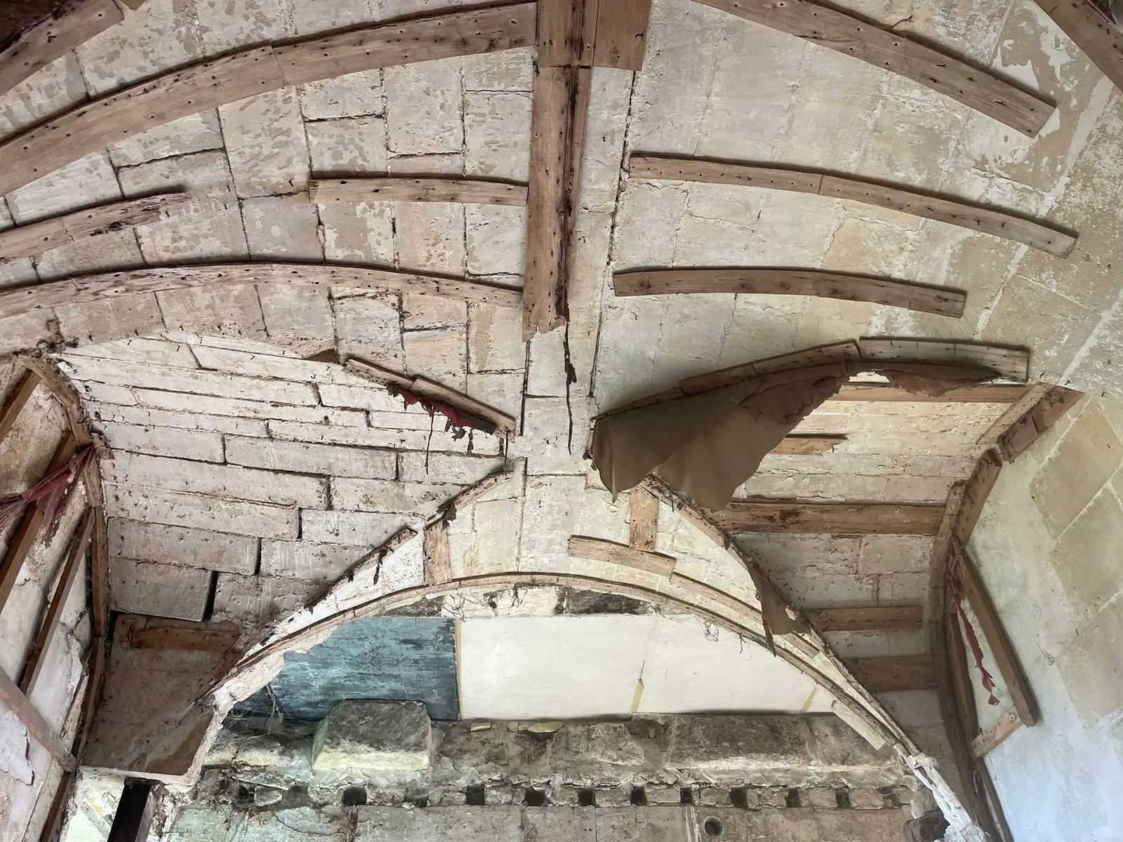 Voûte d'arêtes avant travaux : arcs de pierre appareillée, remplissage de brique et de moellons, charpente et solives apparentes